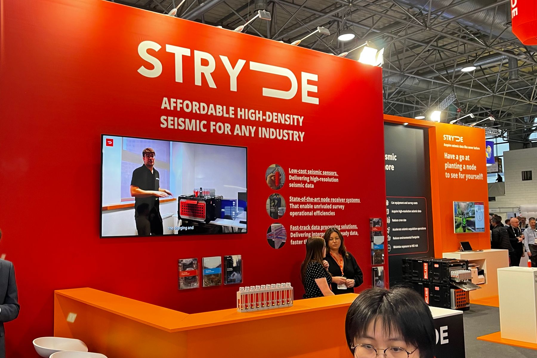 Full-height red wall reading Affordable high-density seismic for any industry, with a screen running the technology at work