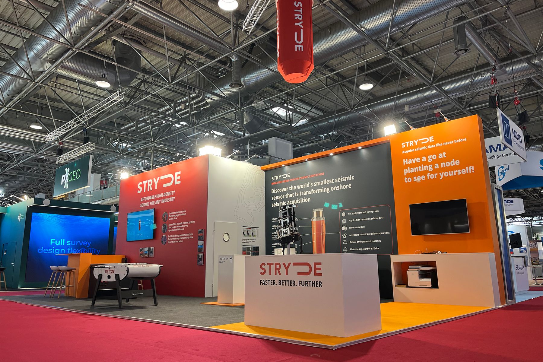 STRYDE's stand at EAGE with its red hero wall and orange node-planting panel