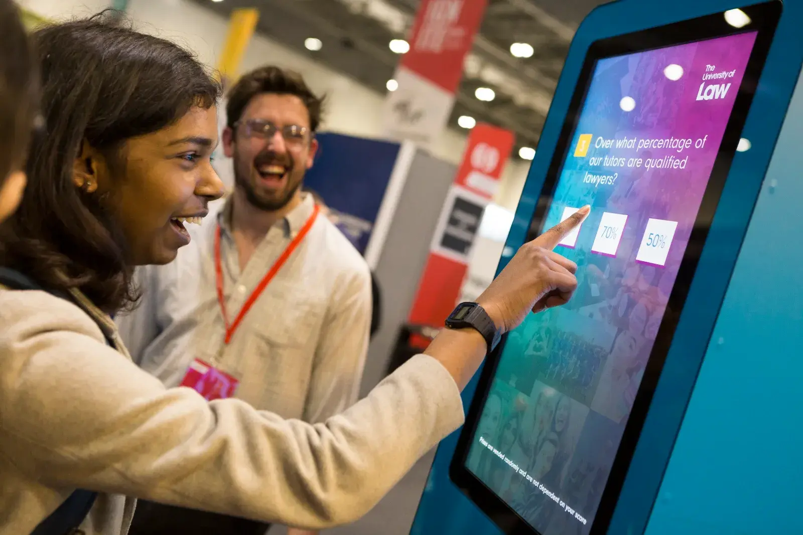 Visitors using a touchscreen quiz on The University of Law stand at UCAS